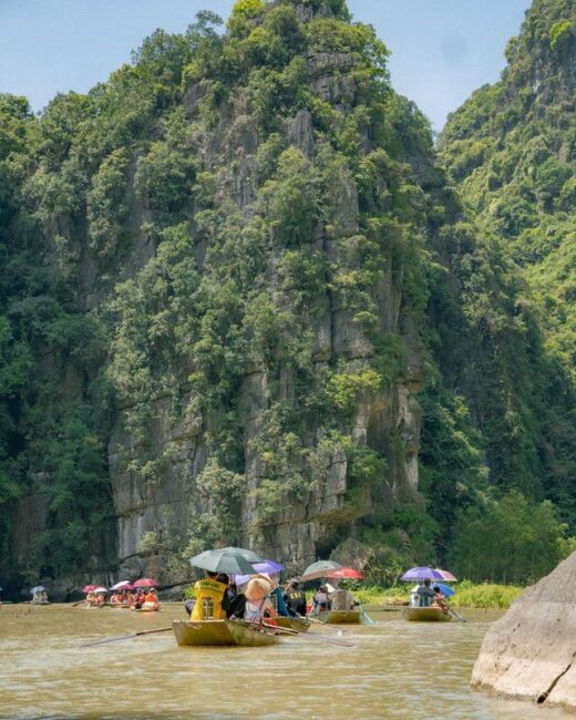 Foreign tourists marvel at the scene of foot boating and cake and sweets being sold on the river in Ninh Binh